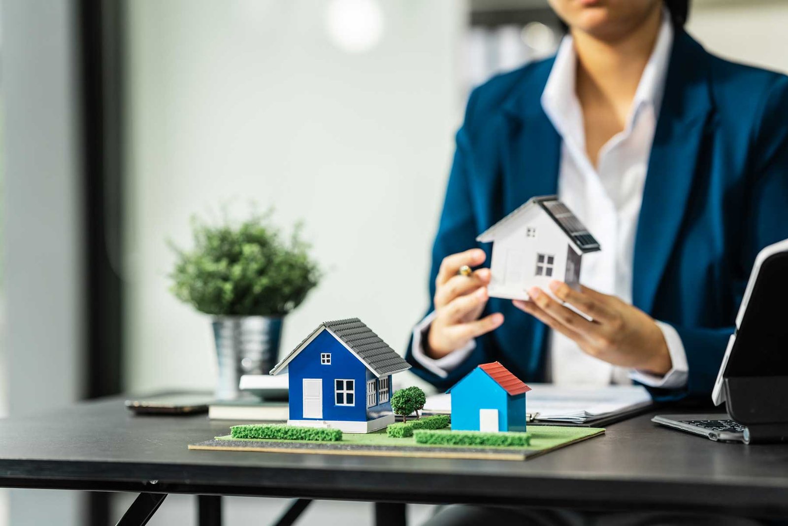 chica mostrando maqueta de ventas de casas 